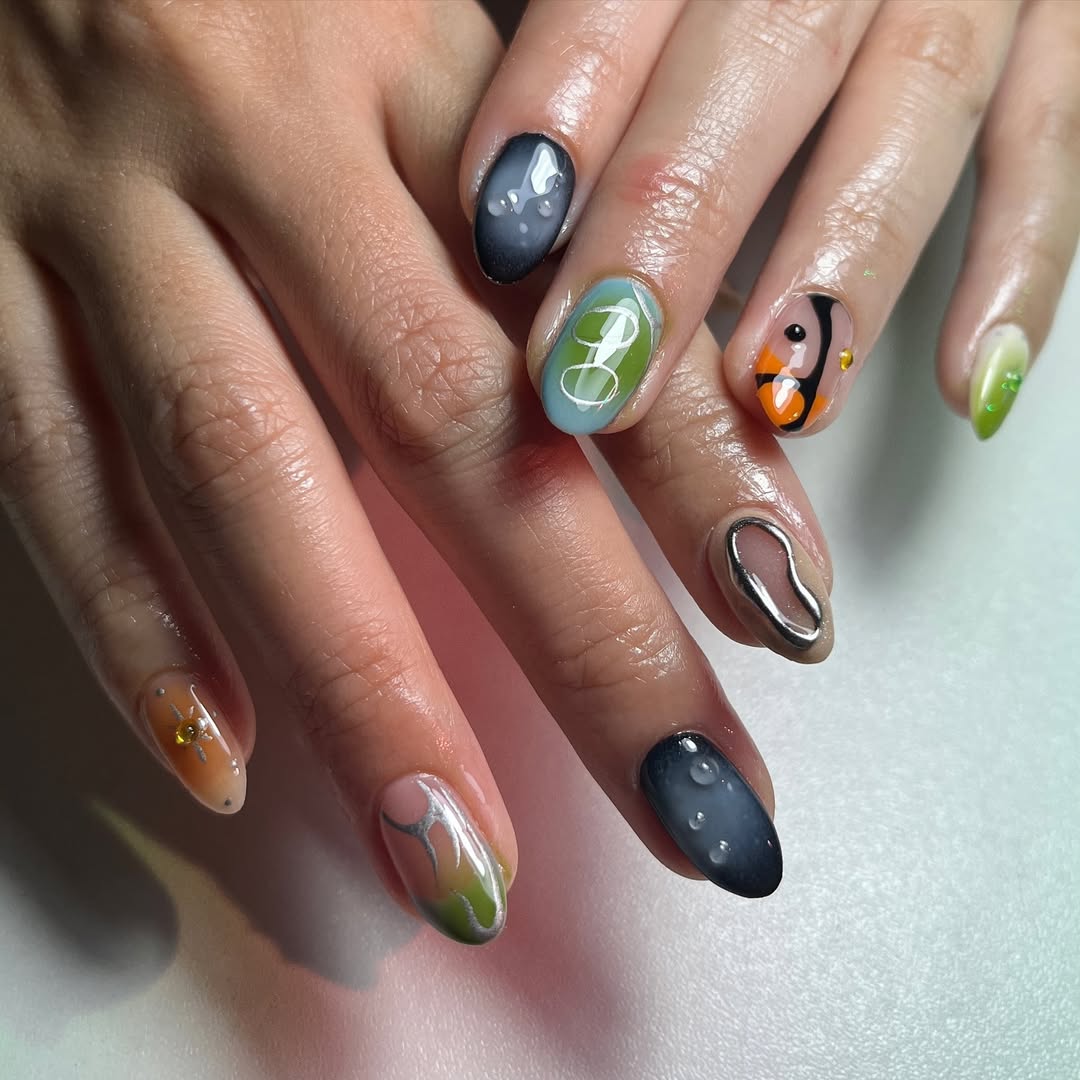 Editorial macro photograph of hand-painted nail art featuring chrome, glossy and hand-illustrated designs