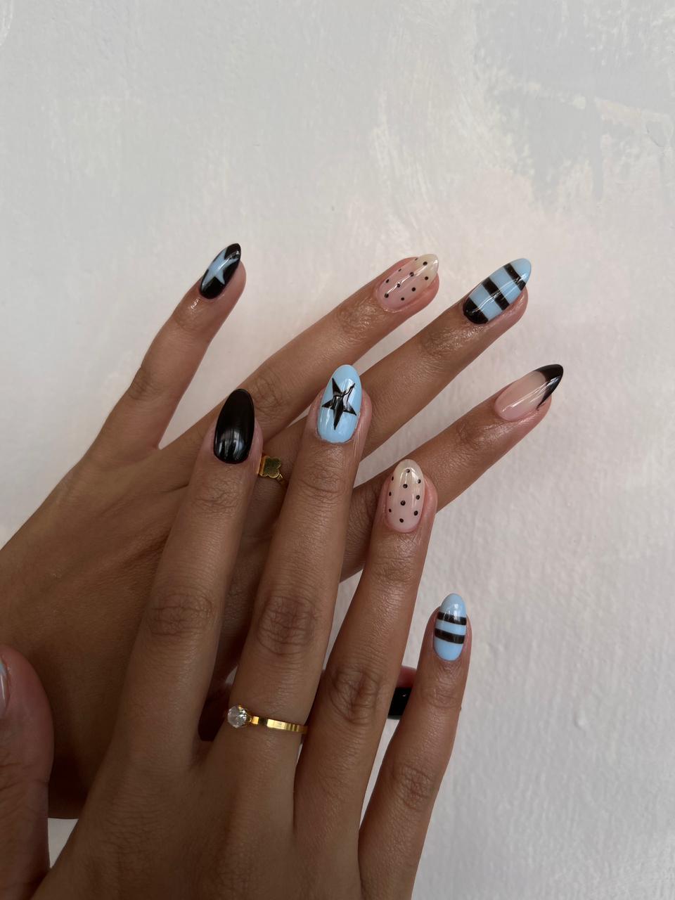 Mixed nail art set with sky blue and black stripes, stars, polka dots and nude accents